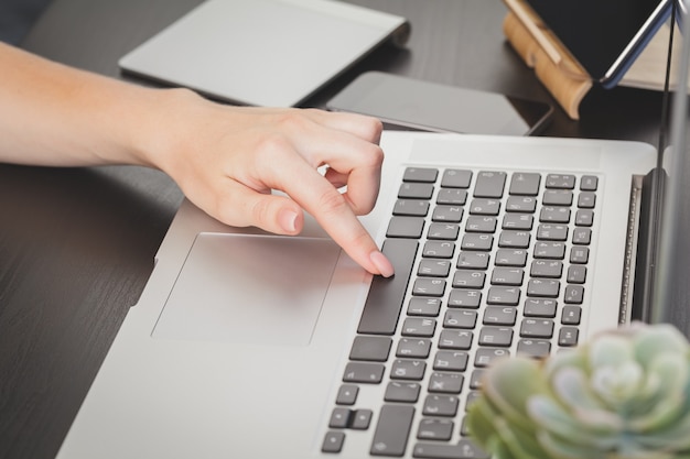 Cerca de una mujer manos de oficinista escribiendo en el teclado