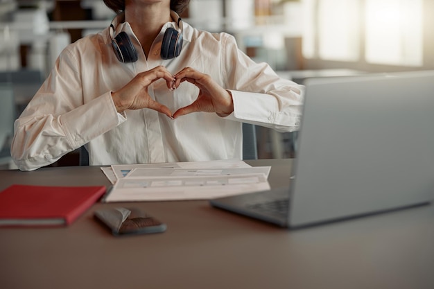 Cerca de una mujer de negocios que trabaja con una laptop mientras se sienta en un café acogedor y muestra amor