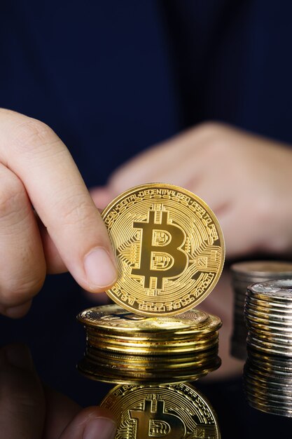 Cerca de mujer sosteniendo algunos trozos de token Bitcoin dorado