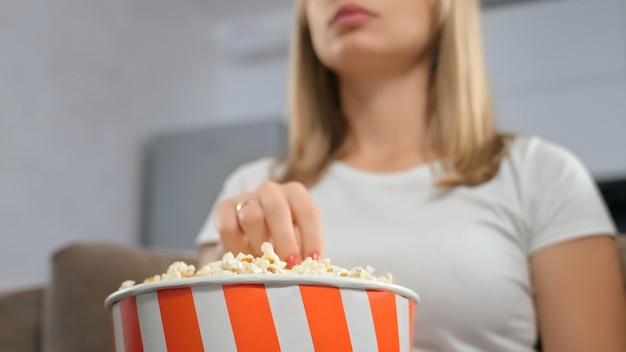 Cerca de mujer sosteniendo caja de palomitas de maíz.