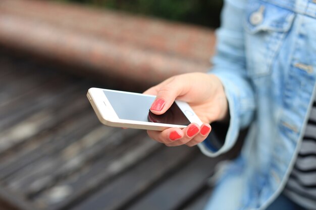 Cerca de una mujer mediante teléfonos móviles inteligentes