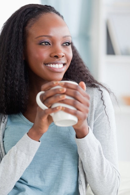 Cerca de la mujer tomando un café en el sofá