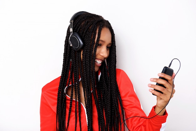 Cerca de la música que escucha joven africana con teléfono móvil y auriculares