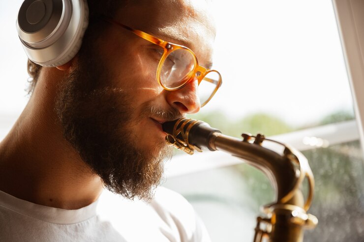 Foto cerca de músico caucásico tocando tambores durante el concierto en línea con la banda en casa aislado