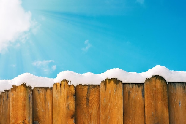 Cerca na neve contra o céu fundo de inverno cópia espaço