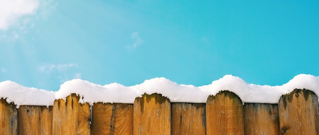 Cerca na neve contra o céu fundo de inverno cópia espaço