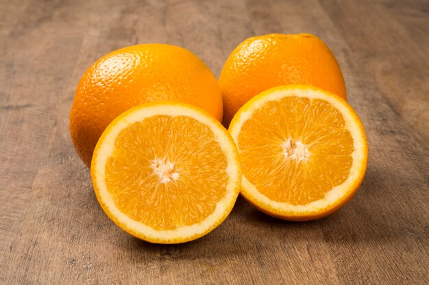 Cerca de unas naranjas en una canasta sobre una superficie de madera. Fruta fresca.