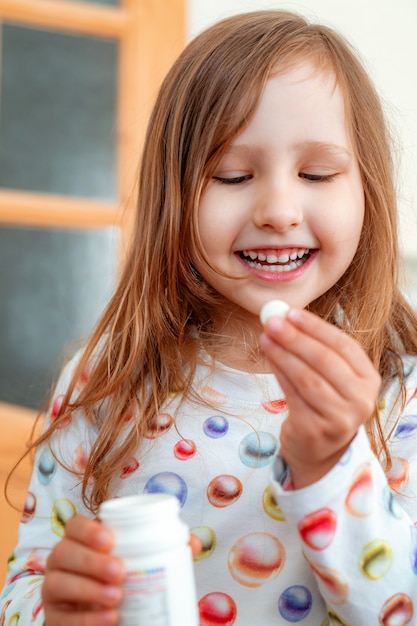 Cerca de niña tomando vitaminas