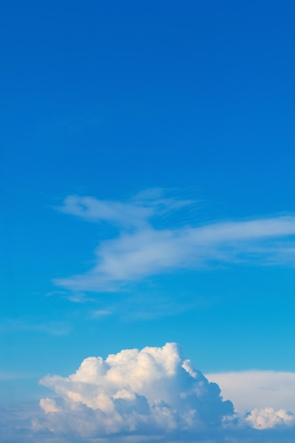 Cerca de la nube rizada debajo del cielo azul en tiempo soleado