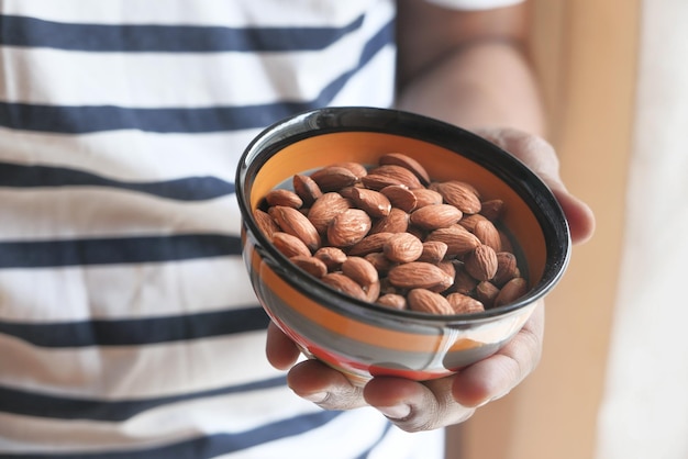 Cerca de nueces de almendra en la mano del hombre