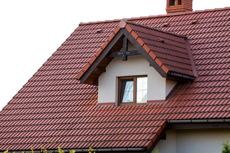 Foto cerca del nuevo techo naranja con chimenea y una pequeña ventana moderna. concepto de techo moderno con elegante pequeña ventana marrón.
