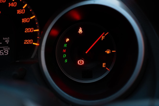 Cerca del panel del medidor con la aguja apuntando a F sobre fondo negro, llene el tanque del carro de gasolina