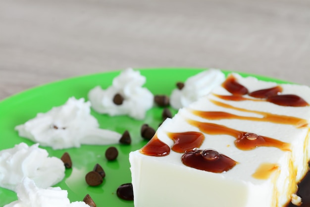 Cerca de una panna cotta con caramelo y crema batida