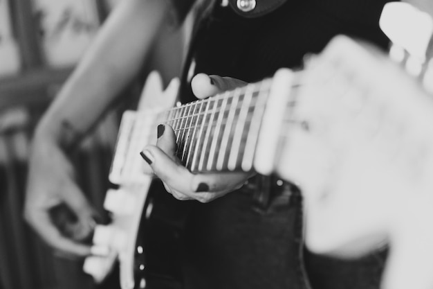 Foto cerca de un par de manos tocando una guitarra al aire libre. día soleado y practicando un concepto de instrumento. copie la vida de la música del espacio en gira y la naturaleza.