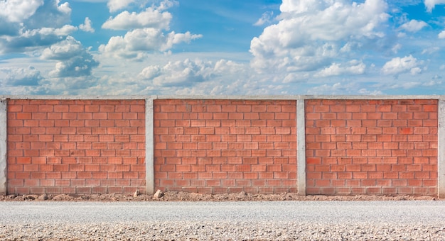 Cerca de la pared de ladrillo rojo con fondo de cielo azul