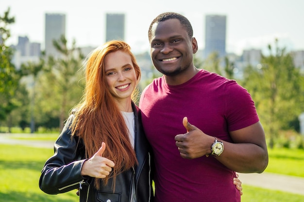 Cerca de una pareja interracial sosteniendo una rosa blanca en el parque primavera otoño