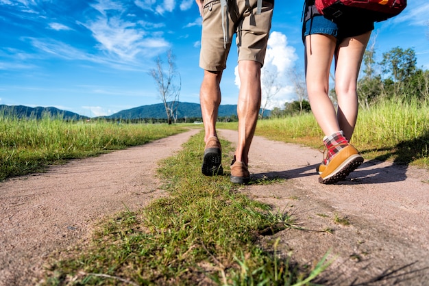 Cerca de la parte inferior de las piernas de dos viajeros caminando por el sendero en la naturaleza