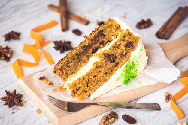 Cerca de un pastel de zanahoria casero con pasas, nueces y canela