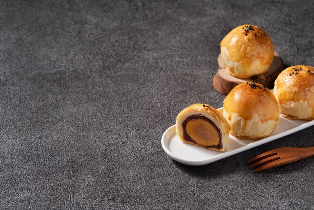 Cerca de pastelería de yema de pastel de luna, mooncake para las vacaciones del Festival del Medio Otoño en el fondo de la tabla gris