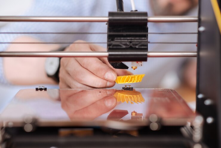 Foto cerca de un pequeño modelo 3d amarillo que se imprime en una máquina de impresión 3d especial