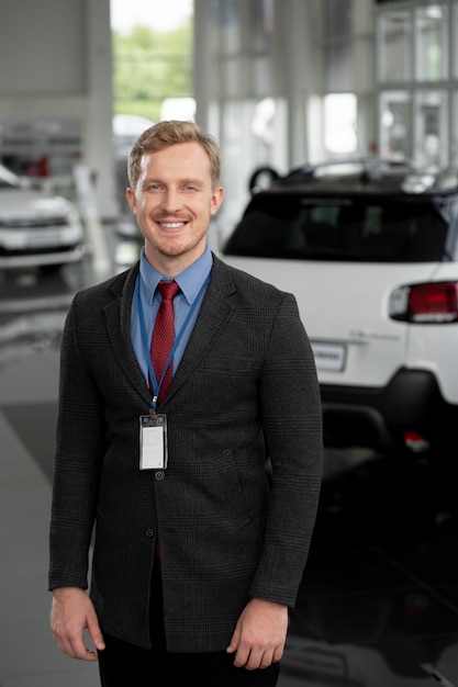 Foto cerca de la persona de negocios feliz en el concesionario de automóviles