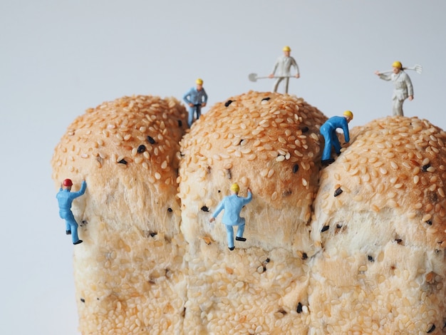 Foto cerca de personas en miniatura muchos de los trabajadores que trabajan en el fondo de pan de grano entero