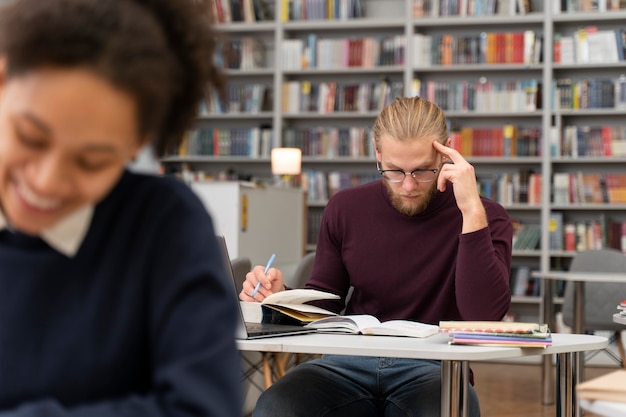 Foto cerca de personas que estudian en la biblioteca