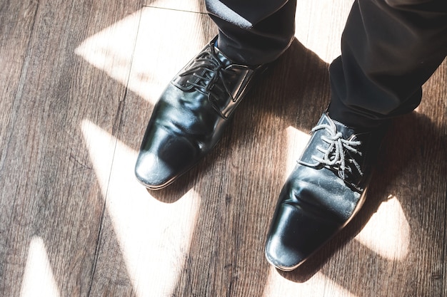 Cerca de las piernas del hombre en zapatos elegantes con cordones. Concepto de moda y calzado