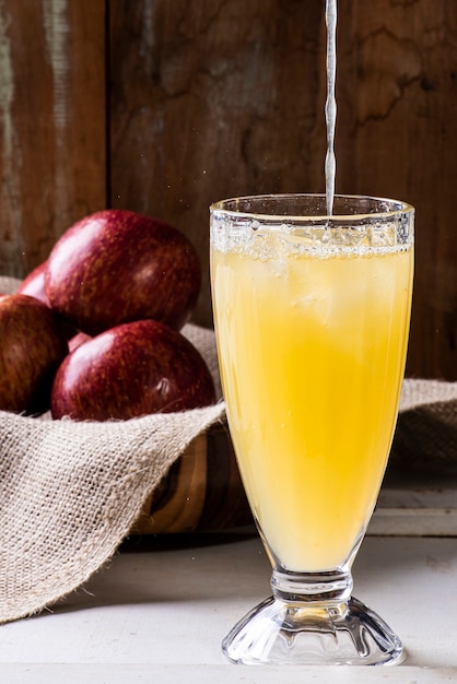 Cerca de la pila de manzanas frescas y maduras con jugo de manzana