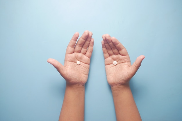 Cerca de píldoras médicas en la palma de la mano del niño