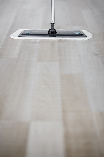 Foto cerca del piso de madera con fregona de microfibra y copie el espacio