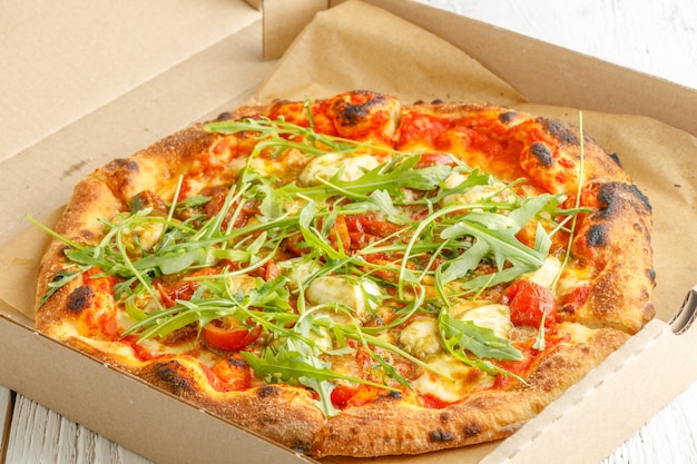 Cerca de pizzas con variedad de verduras y queso en cartón