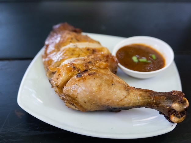 Foto cerca de pollo al fuego sobre la mesa de madera