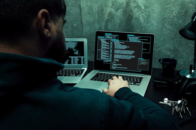 Cerca del programador de manos de hacker escribiendo un código