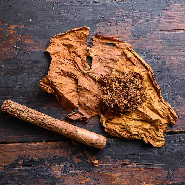 Foto cerca de puros y hojas de tabaco secas