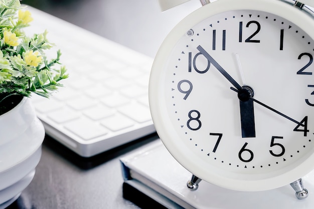 Cerca de reloj despertador blanco en mesa blanca