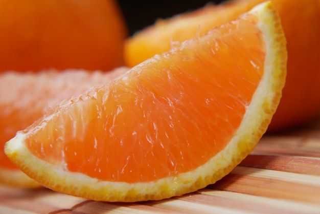 Cerca de una rodaja de fruta naranja sobre fondo de color