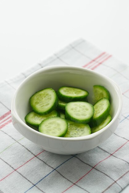 Cerca de una rodaja de pepino en un recipiente sobre la mesa