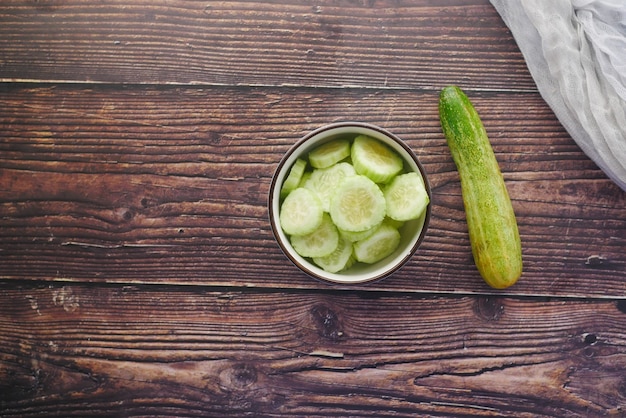 Cerca de una rodaja de pepino en un recipiente sobre la mesa