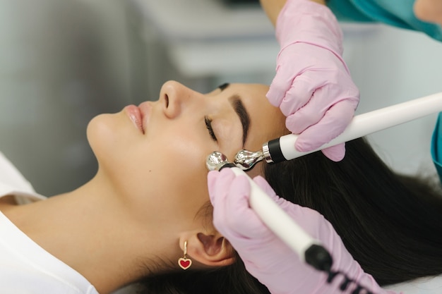 Cerca del rostro femenino con piel suave. Mujer en la clínica de cosmetología tomando un procedimiento de belleza para