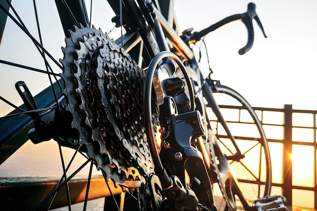 Cerca de una rueda de bicicleta con detalles de engranajes en el amanecer de la mañana