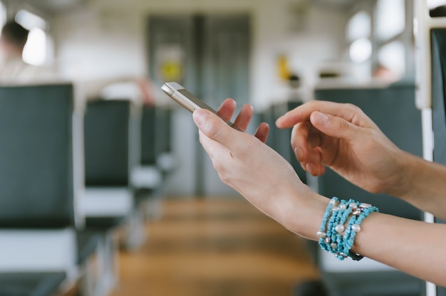 Cerca de smartphone en mano femenina en tren