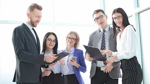 De cerca. sonriente equipo de negocios con documentos comerciales. concepto de éxito