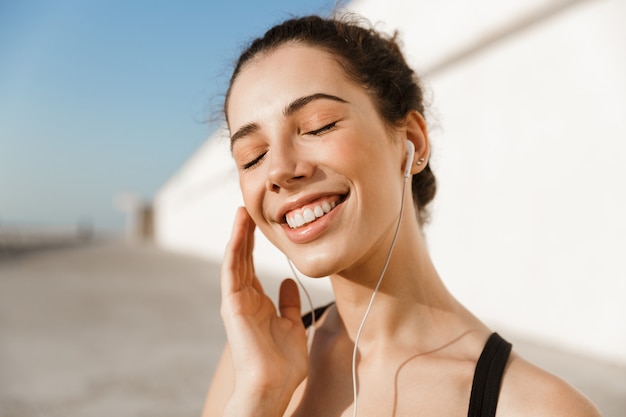 Cerca de sonriente joven deportista en la playa