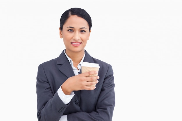 Cerca de sonriente vendedora con taza de papel