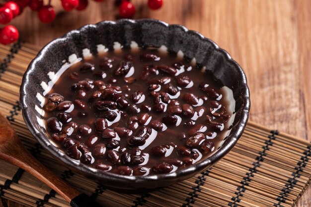 Cerca de la sopa de frijoles rojos adzuki en un recipiente sobre fondo de mesa de madera para comer.