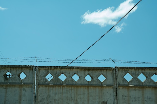 Cerca soviética concreta com fio contra o céu