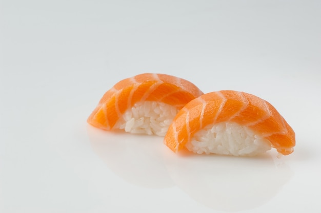 Cerca de sushi con arroz sobre fondo blanco con reflejo