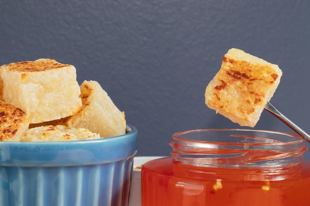 Cerca de tapioca y queso en cubo (dadinho de tapioca) servido con jalea de pimienta.