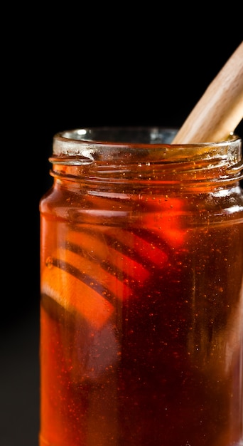 Cerca de un tarro de miel con un cucharón de miel